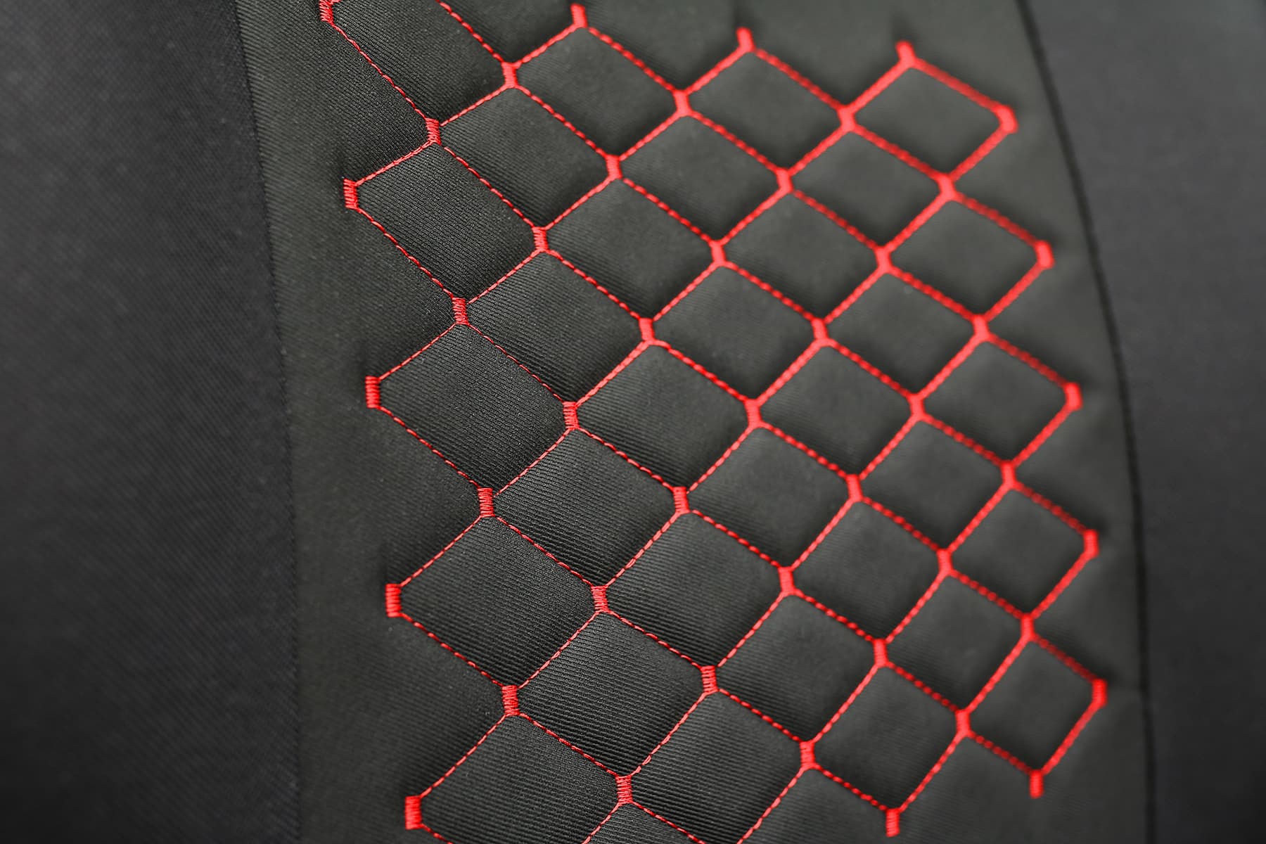 Detail des Polsterstoffs und der roten Nähte der Motive Autositz-Shirts